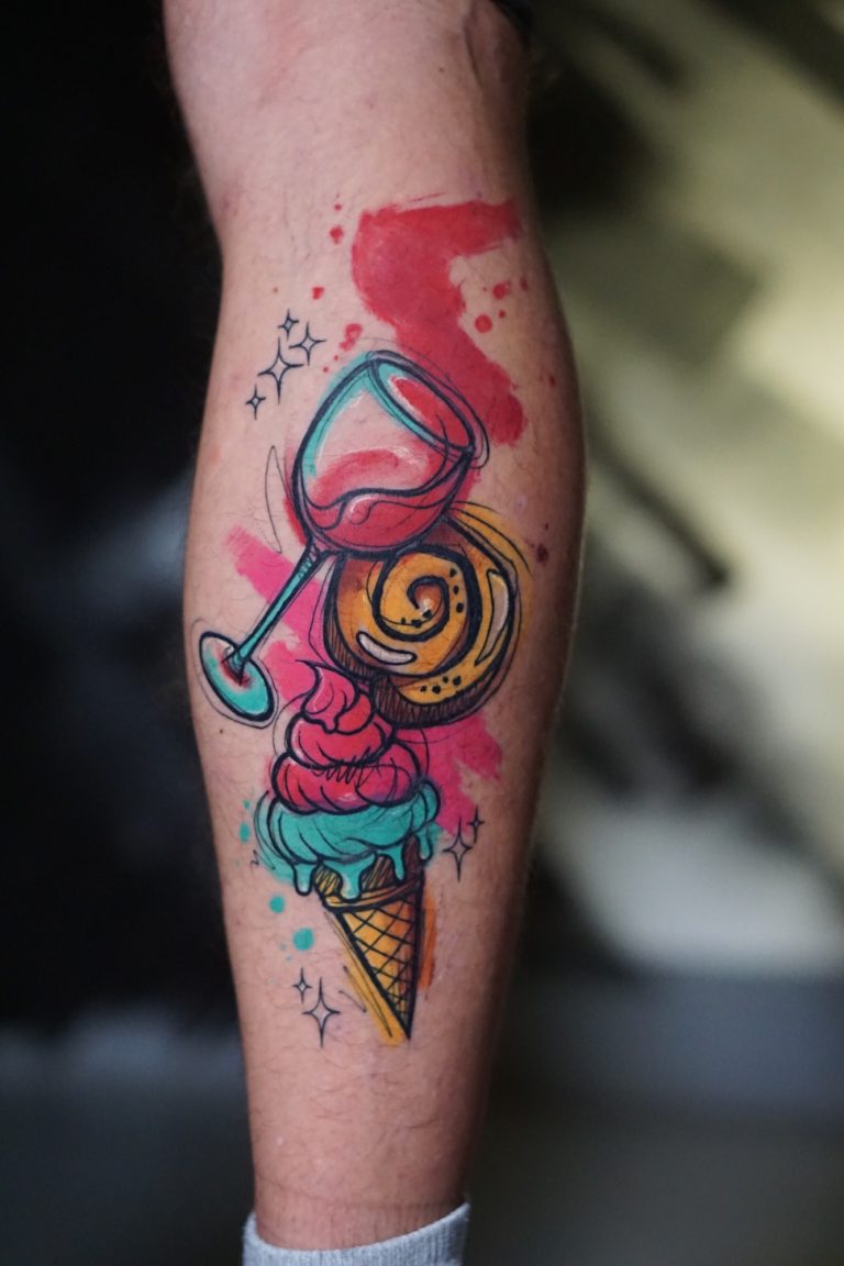 Buntes Tattoo eines Weinglases, einer Eistüte und einer Spirale auf einem Unterarm.